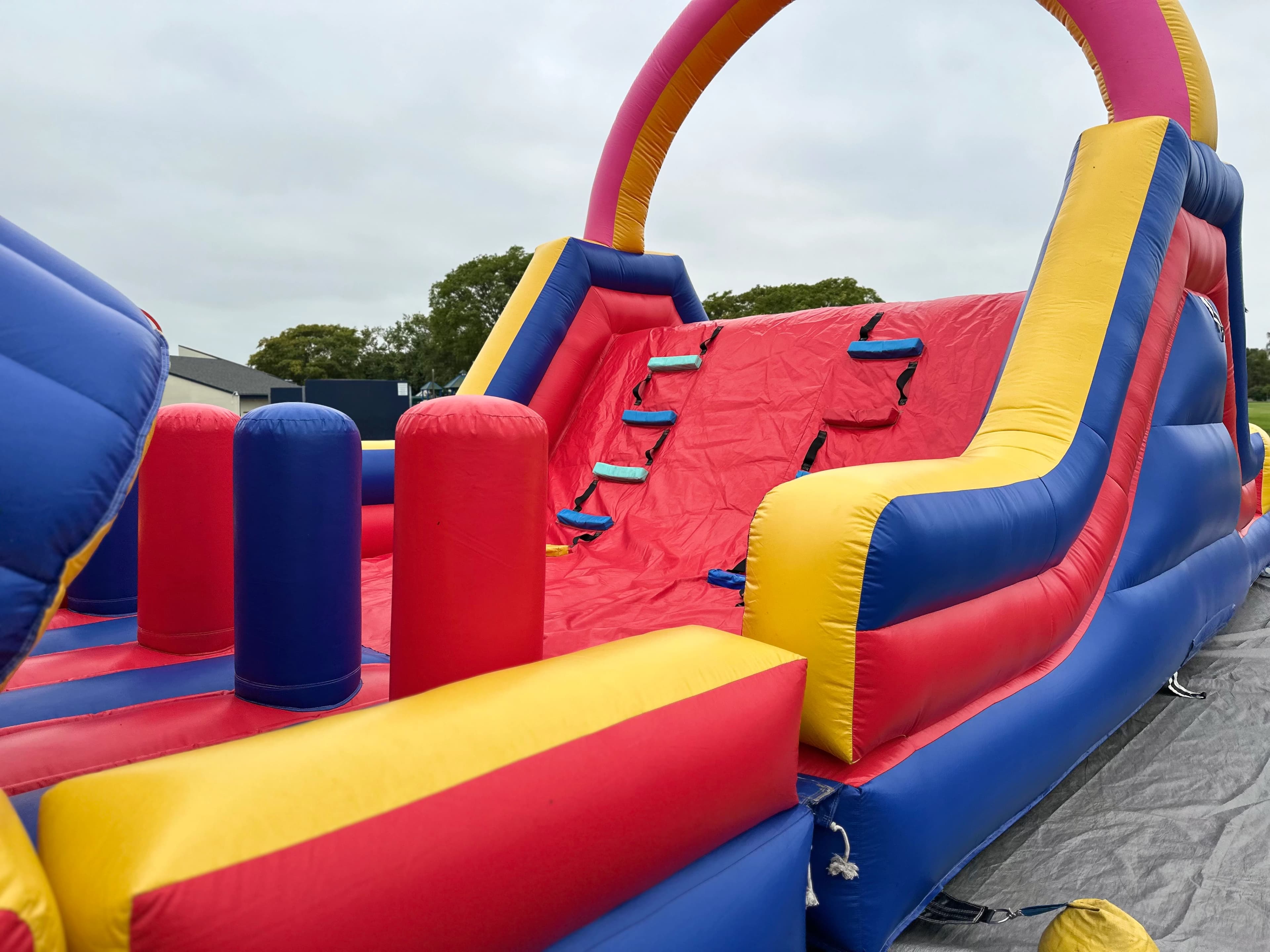 Climb wall and slide section of the Funnel Run Course with bright red steps and dual-lane exit.