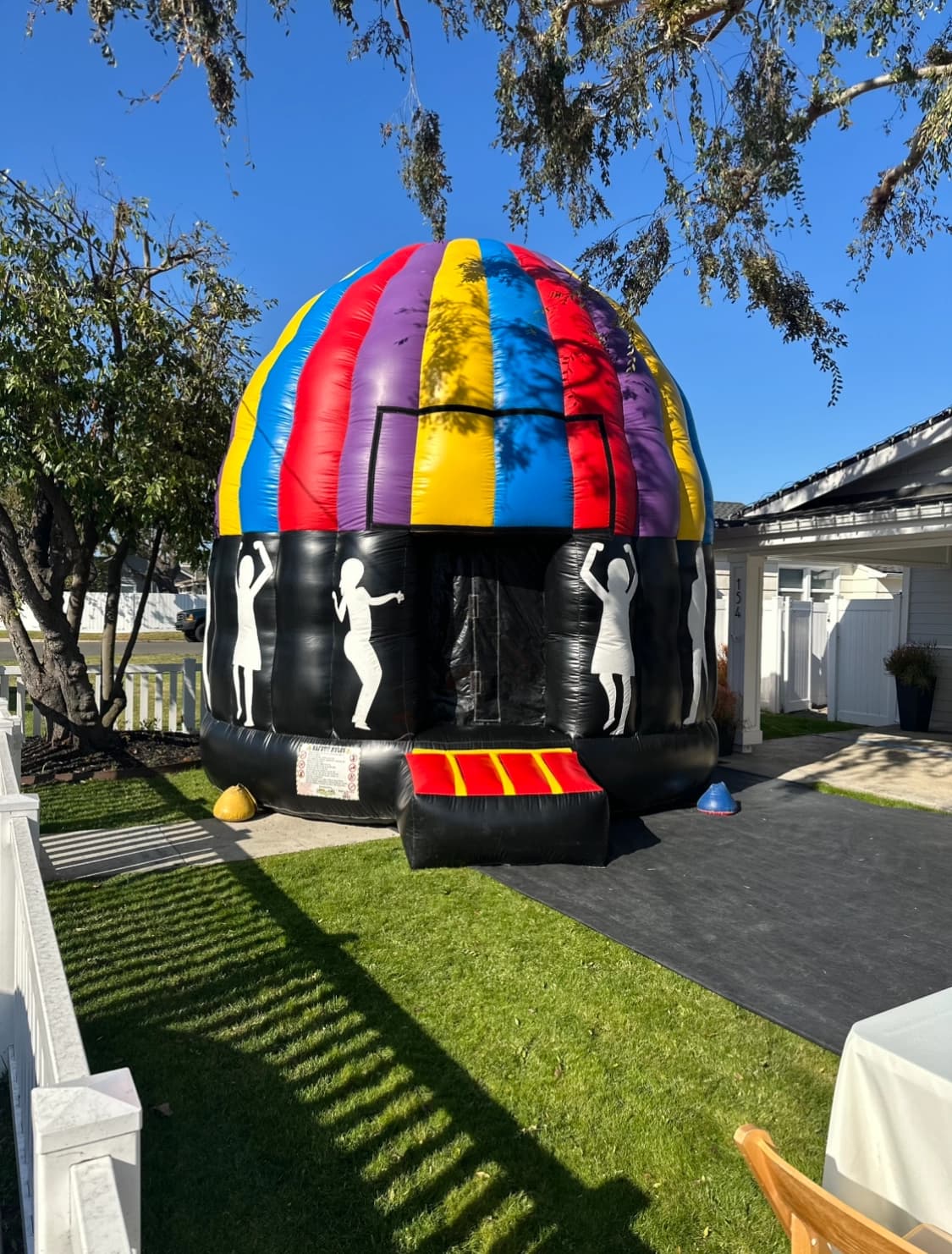 Alternate daylight exterior view of the Incredible Dance Party Dome Jumper showing entrance and inflated walls.