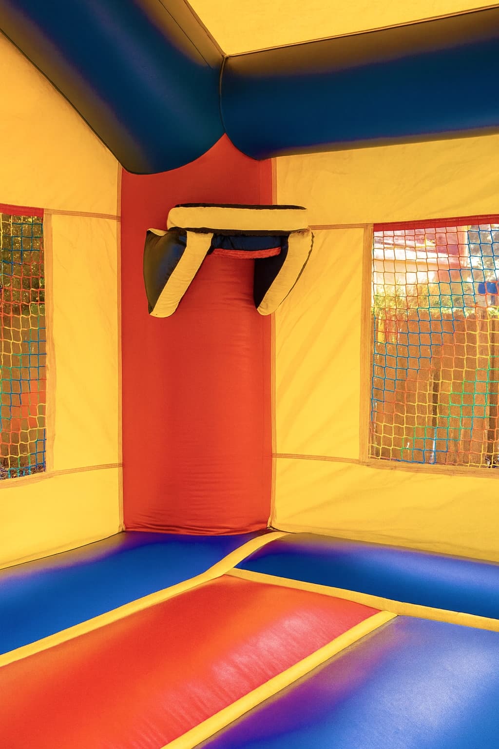 Basketball hoop feature inside the Jumpland Castle bounce house above the padded back wall area.