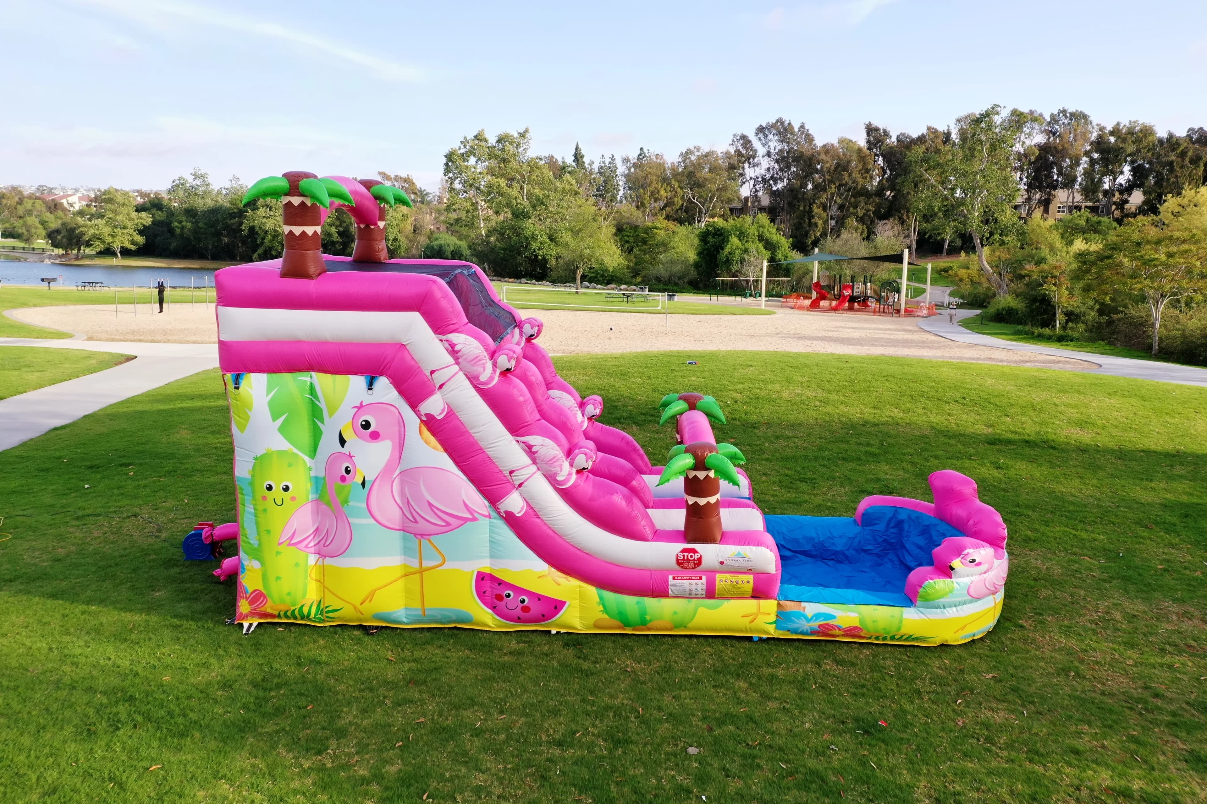 Angled view of the Pink Flamingo Paradise Water Slide highlighting pink slide lanes, palm tree arches, and splash pool.