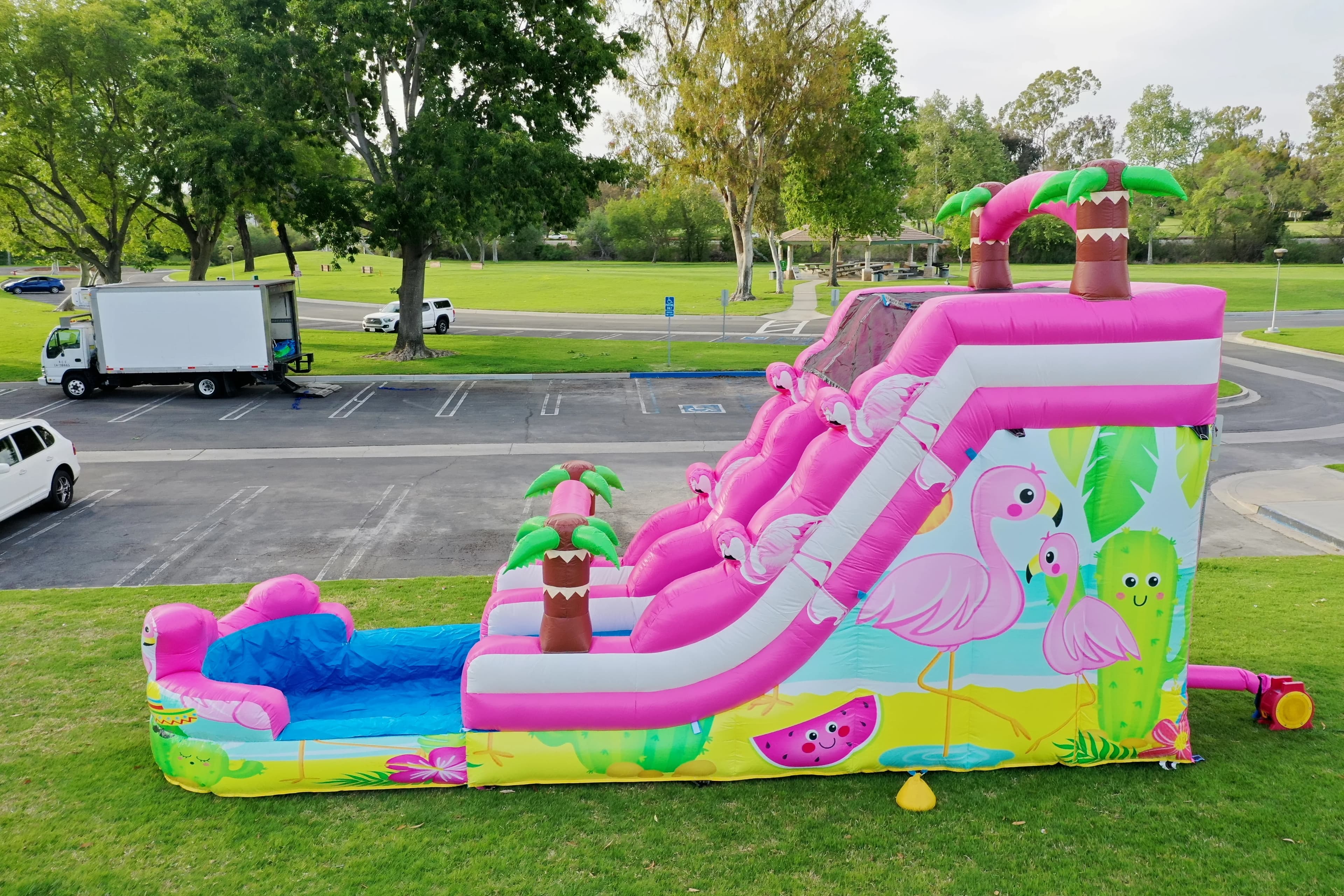 Side view of the Pink Flamingo Paradise Water Slide showing full length, climb ladder, and tropical artwork.