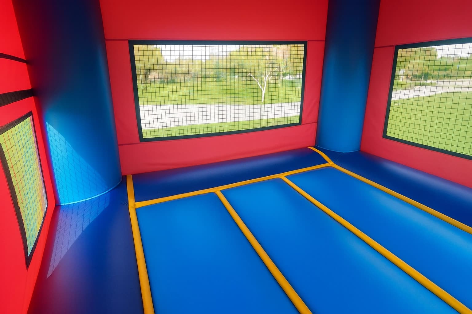 Alternate interior angle of the Pink Wonder bounce house showing jump floor, mesh walls, and inflated columns.