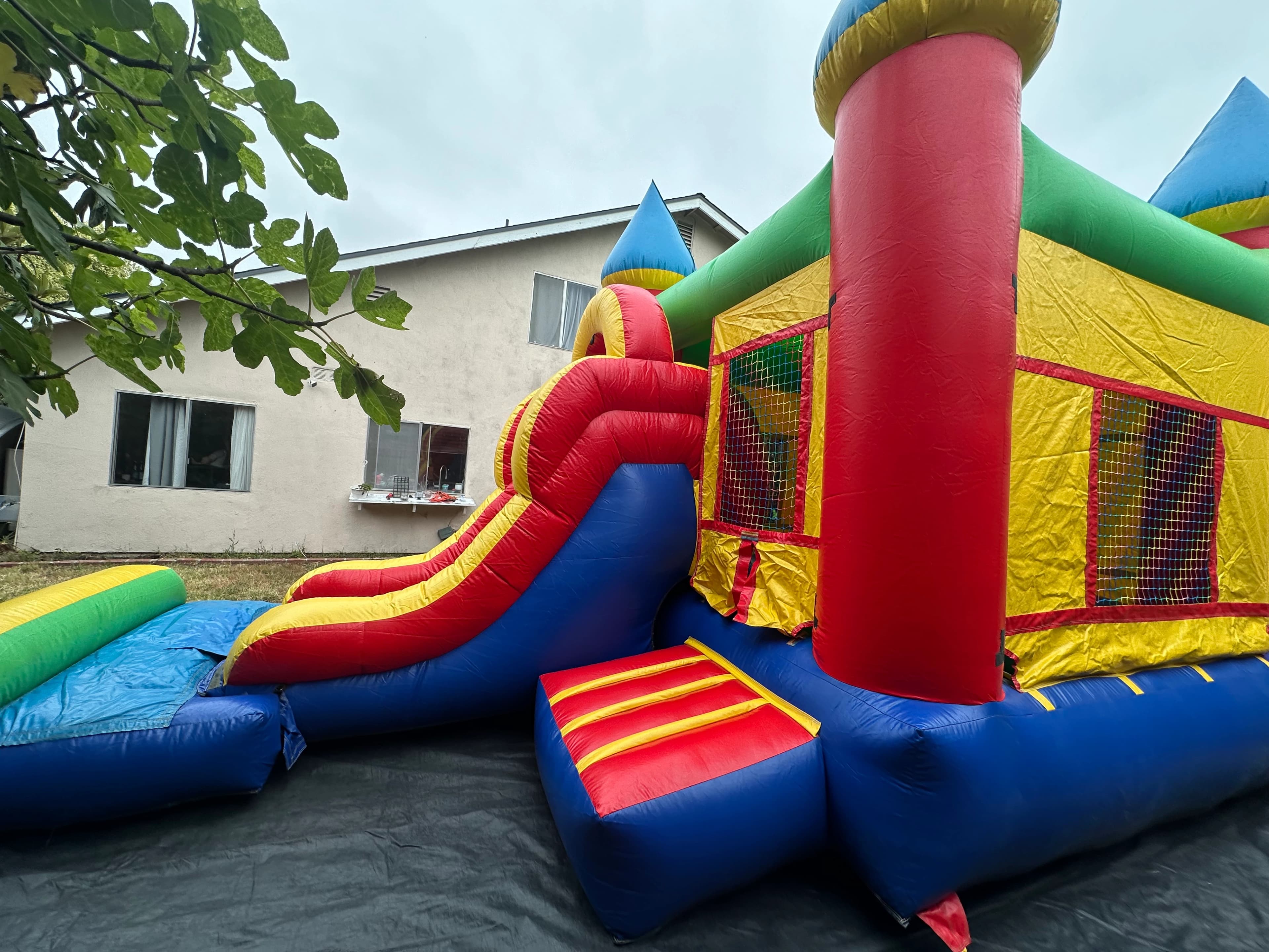 Alternate interior angle of the Rainbow Castle Combo showing open jump area and mesh walls.