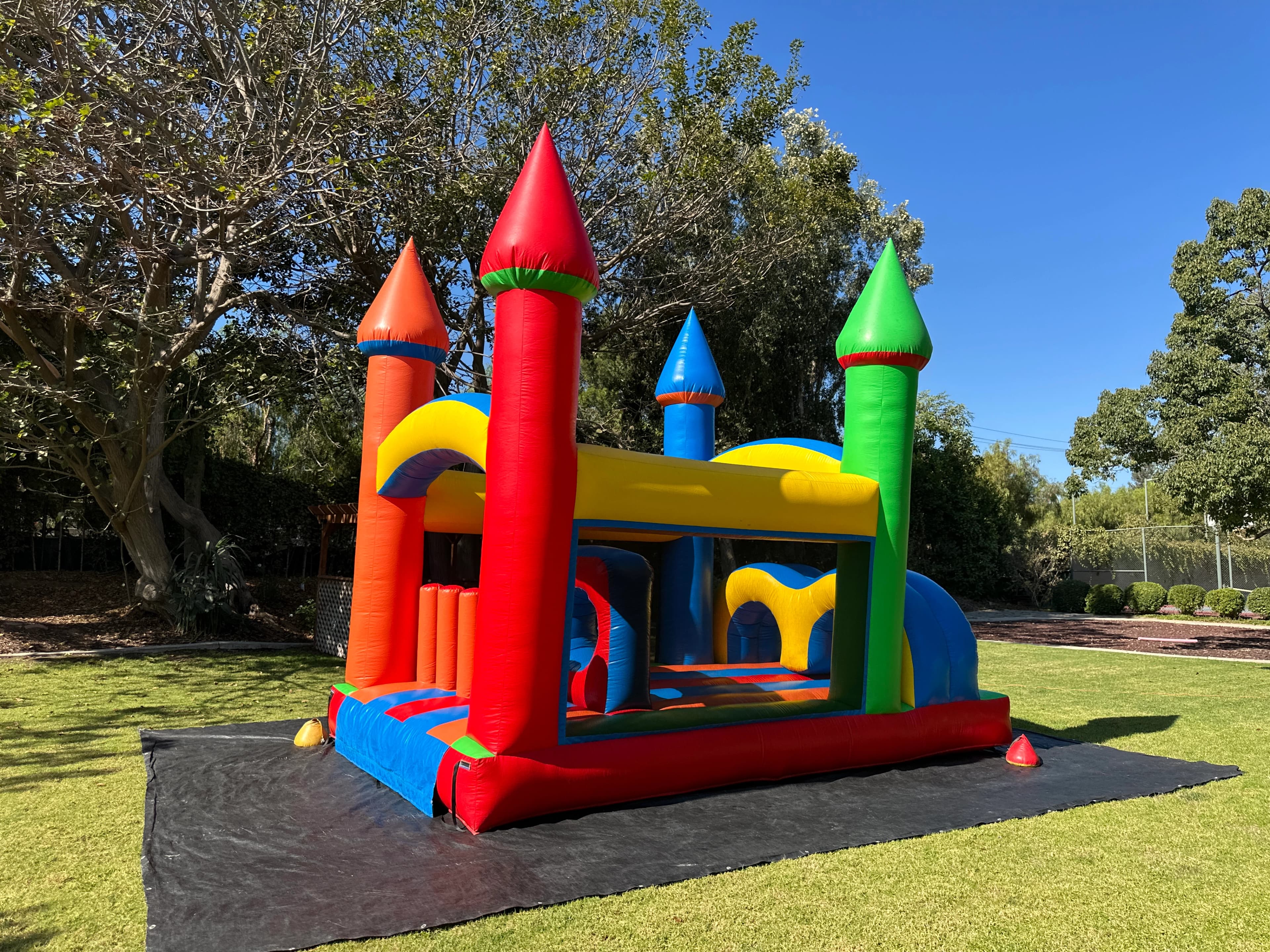 Rear-side exterior angle of Rainbow Tunnel Rush highlighting arched tunnels, slide approach, and castle spires.