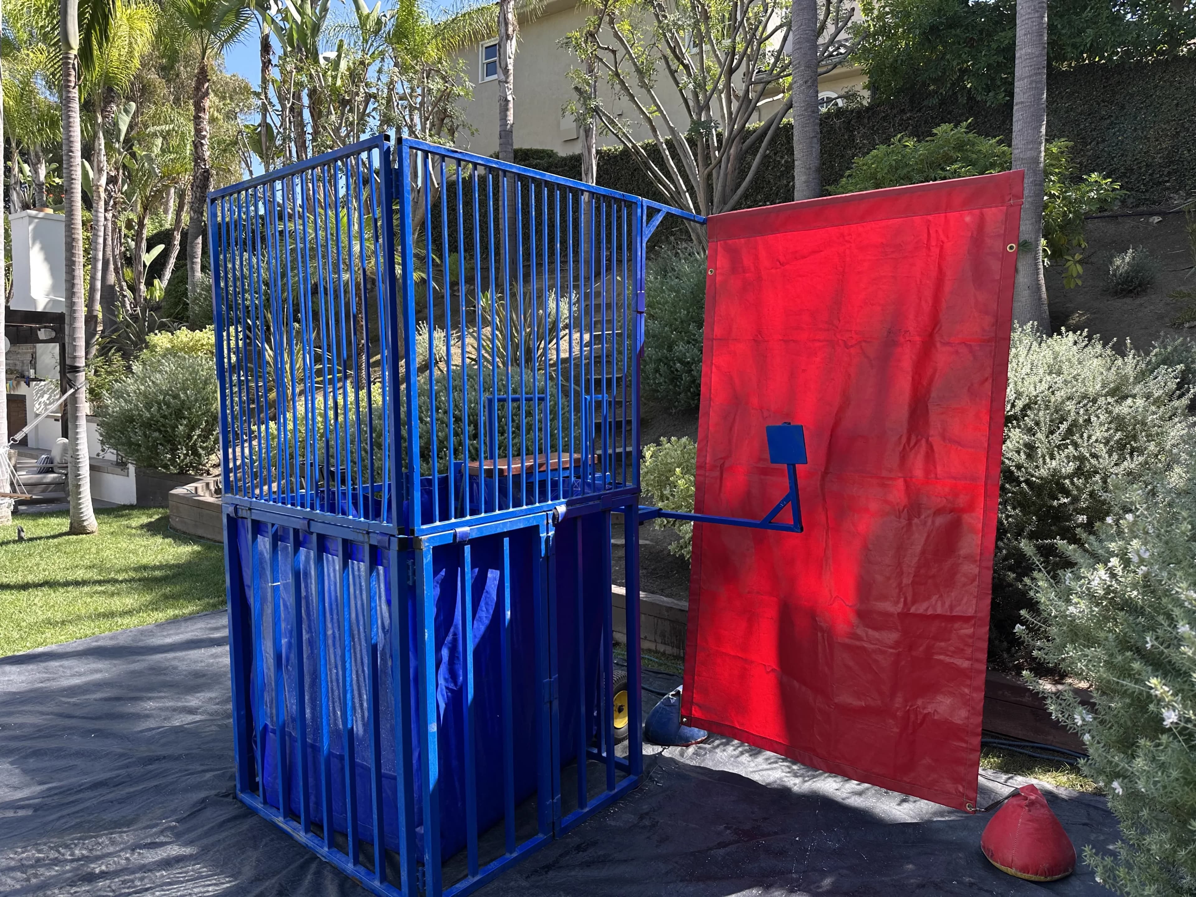Close-up view of the Standard Blue Dunk Tank showing the bright red target, steel frame, and padded seat details.