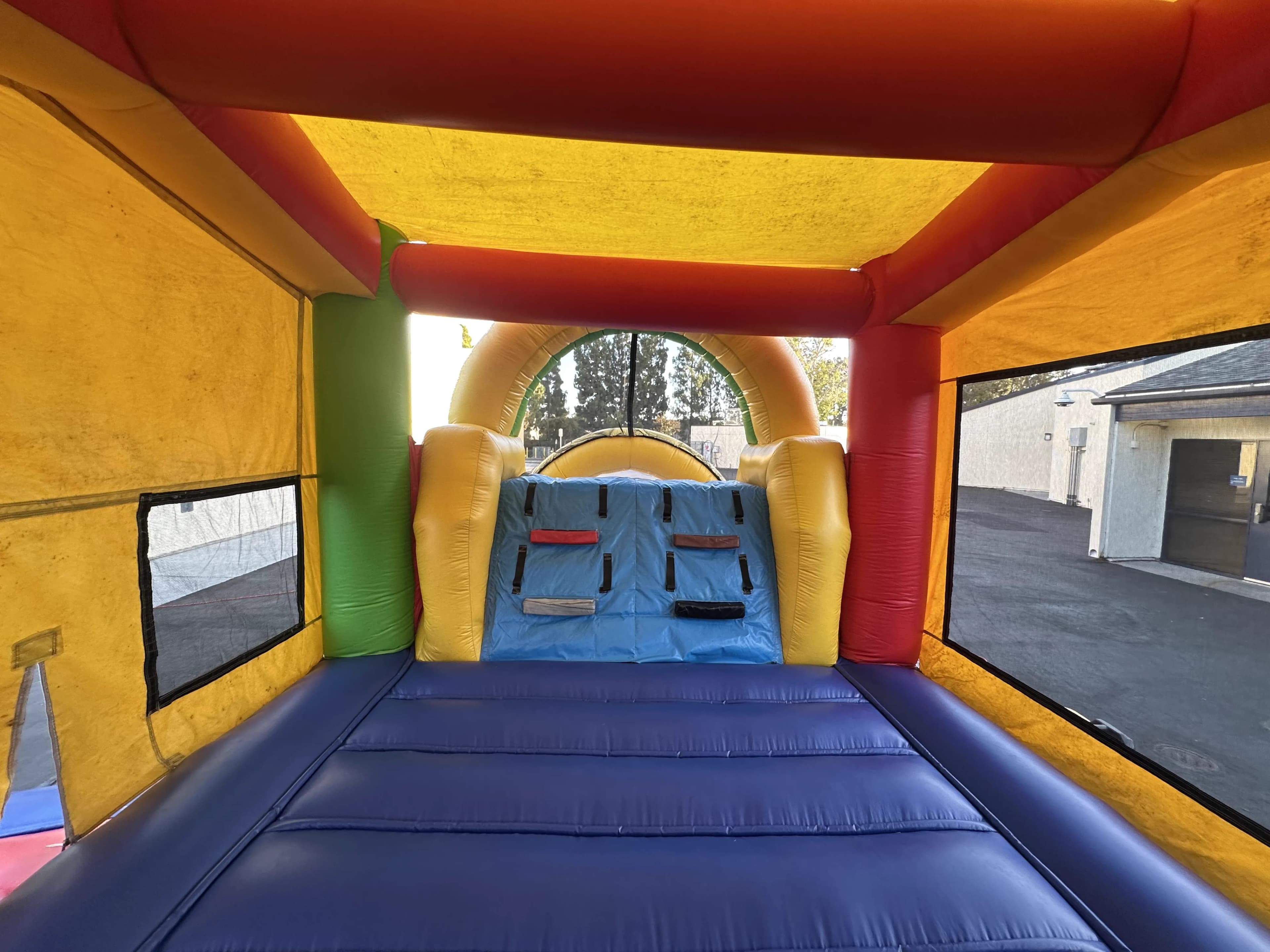 Wide interior shot of the Super 6 in 2 Fun Run Obstacle Combo capturing the full breadth of the course with bounce deck, climb wall, and slide chute in one frame.
