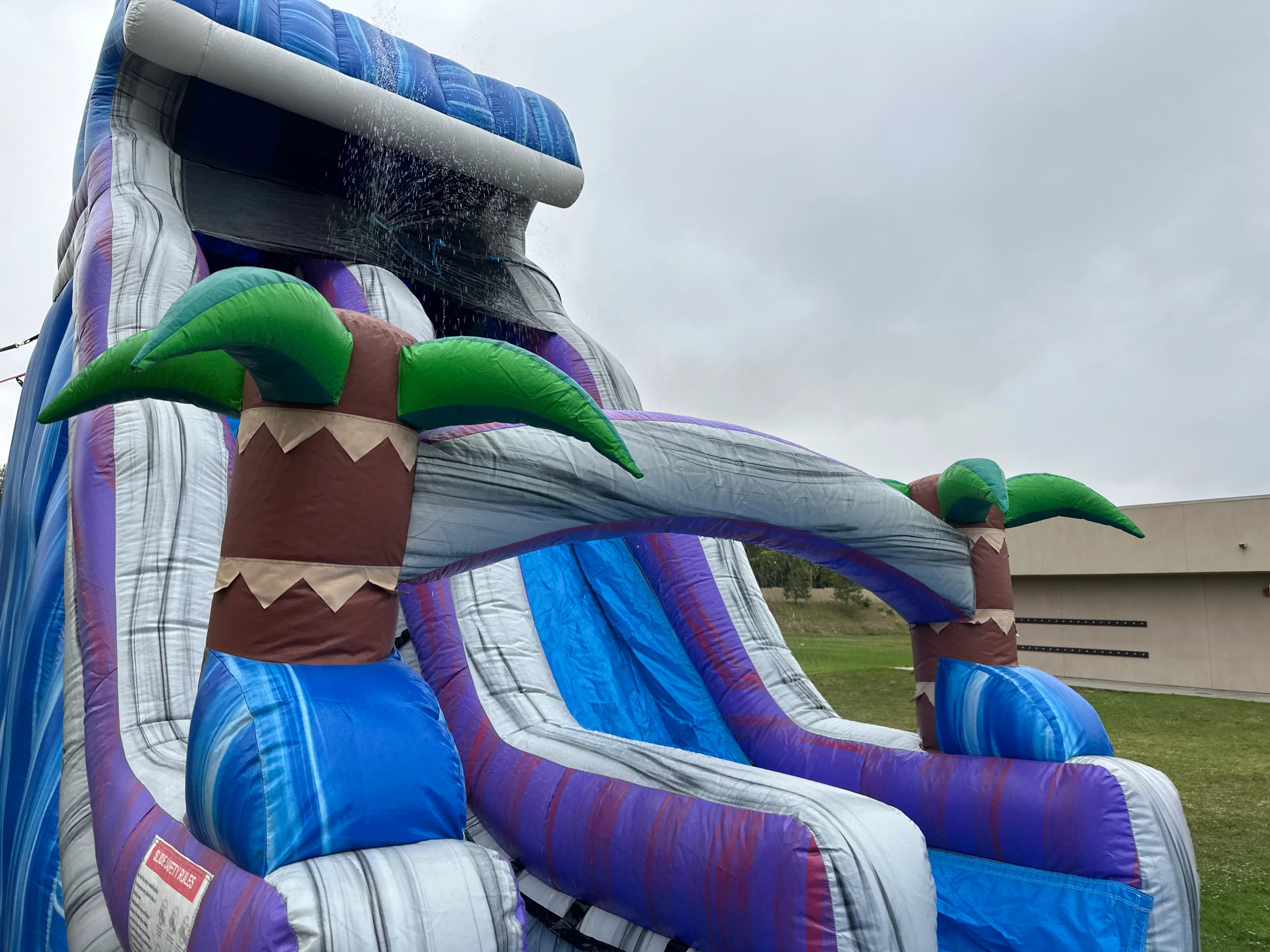 Centered front view of the Tropical Surge 22-Foot water slide highlighting tall drop and safety netting at the top.