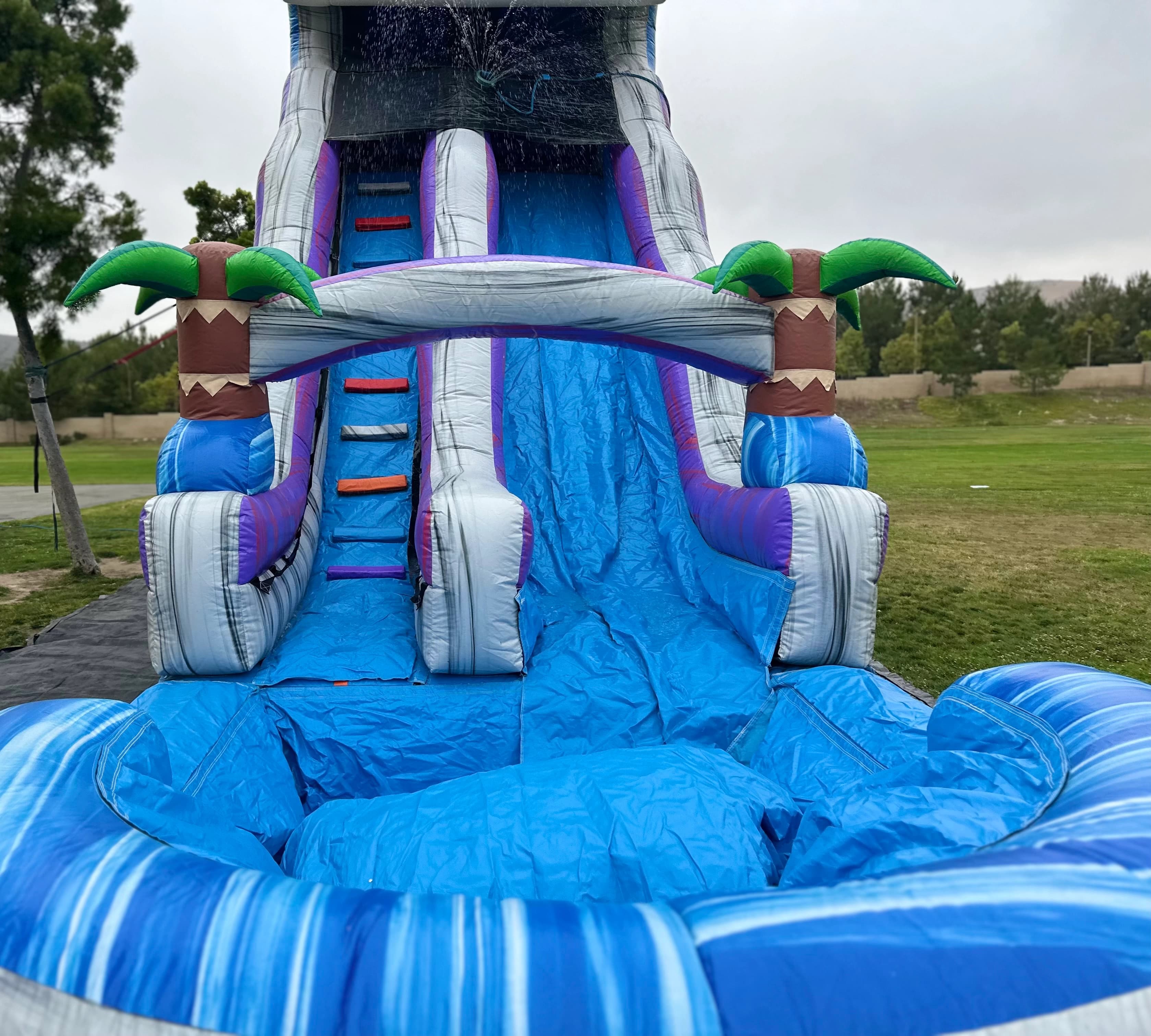 Straight-on slide lane view of the Tropical Surge 22-Foot water slide with padded sides and water flowing down.