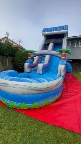Outdoor front angle of the Tropical Surge Water Slide set up for an event.