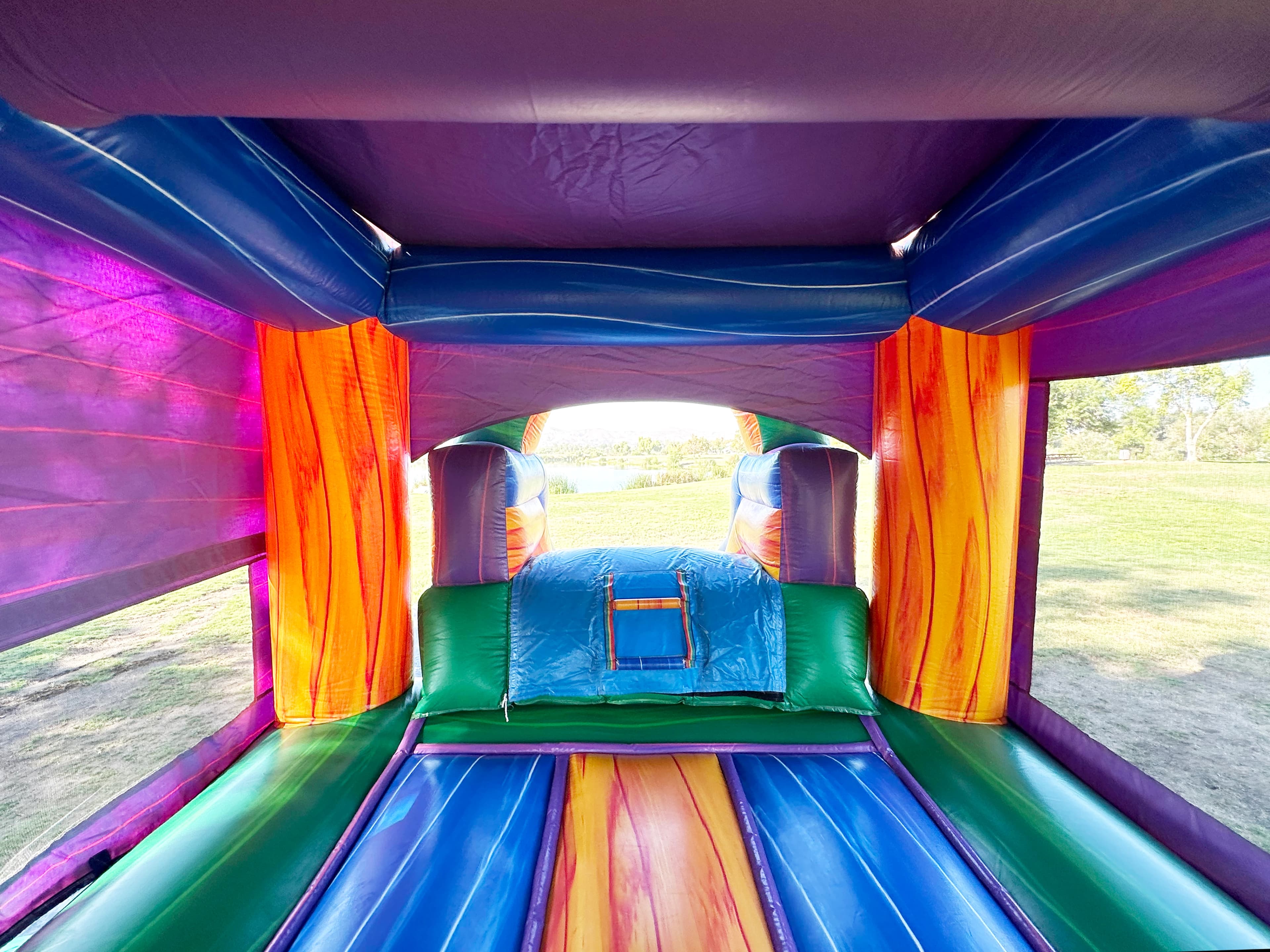 Outdoor front view of the Warrior Titan 4-in-1 castle combo showing slide and entry step.